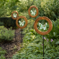 Four Mirthwick glass butterfly garden stakes in a planted garden border