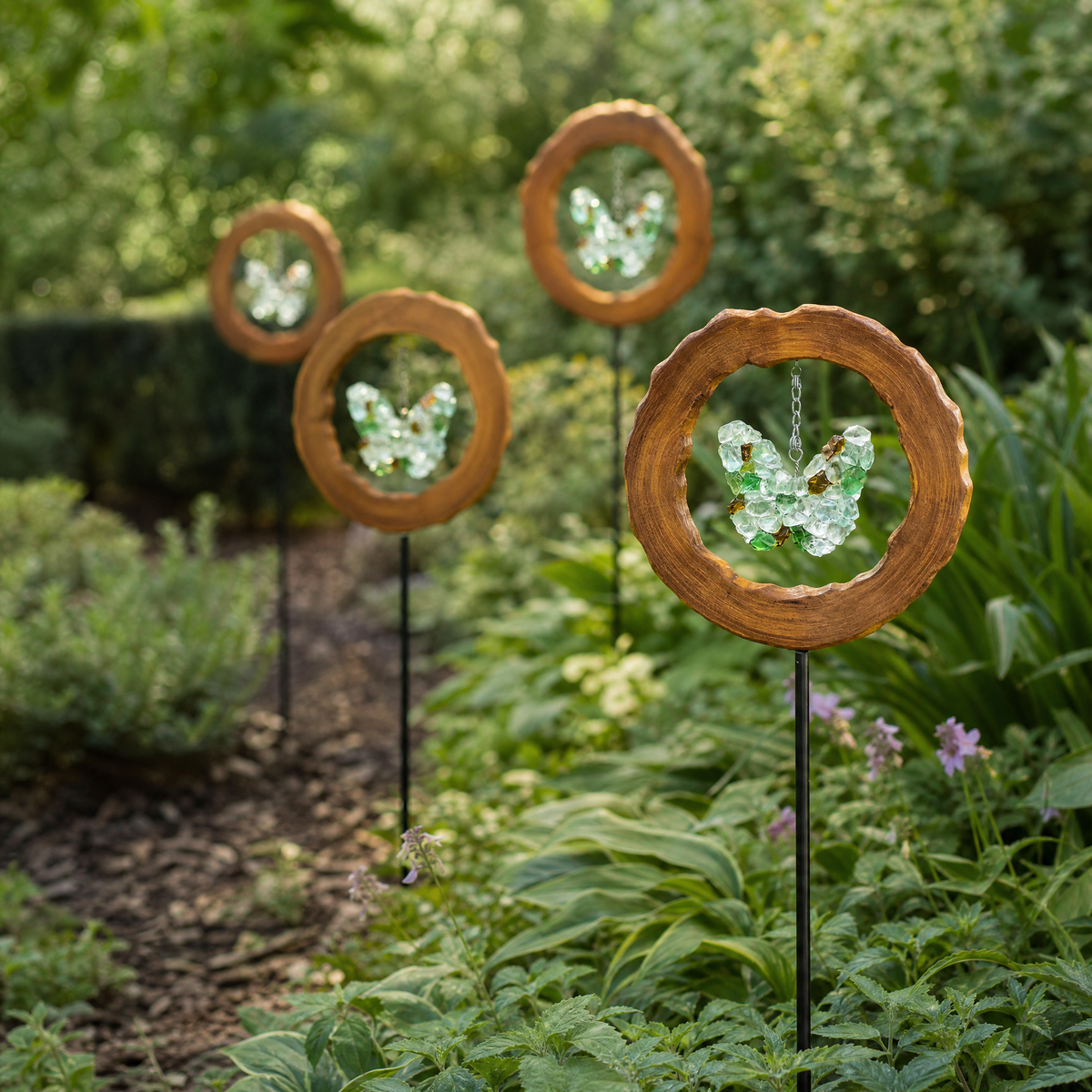 Four Mirthwick glass butterfly garden stakes in a planted garden border