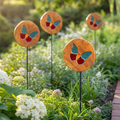 Four Mirthwick stained glass butterfly garden stakes in a planted garden border