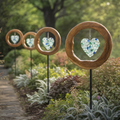 Four Mirthwick glass heart garden stakes in a planted garden border