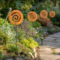 Four Mirthwick spiral garden stakes in a planted garden border