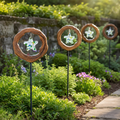 Four Mirthwick star garden stakes in a planted garden border